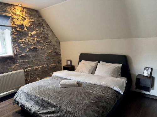 a bedroom with a large bed with a stone wall at I&A Residence - Old Town in Tallinn
