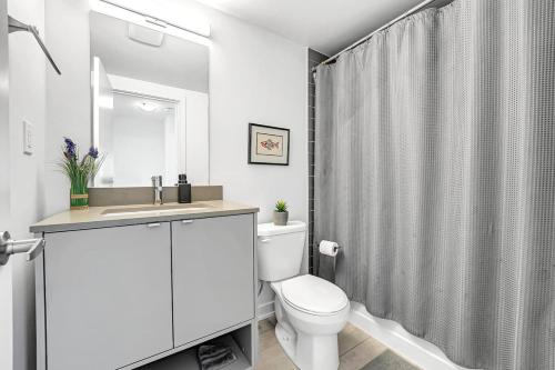 a white bathroom with a toilet and a sink at Ritzy 3BR Home with Balcony Near Burlington Pier in Burlington
