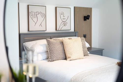 a bedroom with a bed with three pictures on the wall at Stylish 2 Bedroom Cottage with Hot Tub and Parking in Bewdley