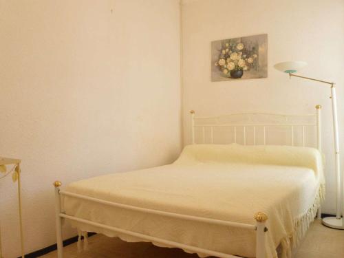 une chambre avec un lit blanc dans une pièce dans l'établissement Appartement Cosy Proche Mer: 2 Pièces, 4 Couchages, Narbonne Plage - FR-1-229B-19, à Narbonne-Plage