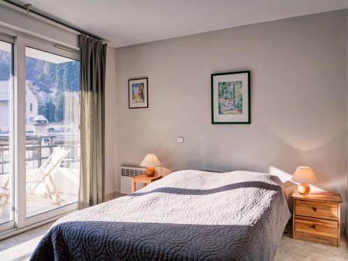 a bedroom with a bed and a large window at Appartement 2* à Brides-les-Bains, 1ch, 2 parkings, balcon sud, proche télécabine et thermes - FR-1-512-2 in Brides-les-Bains