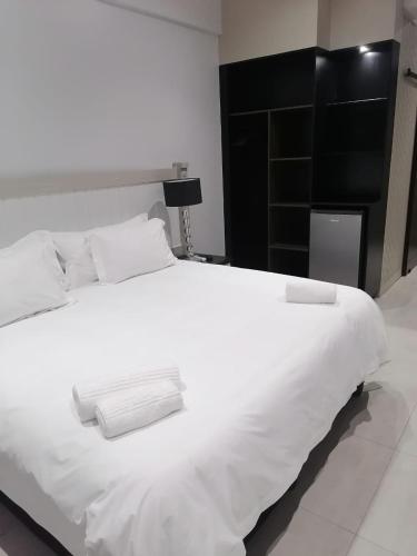 1 cama blanca grande con cabecero negro en un dormitorio en Pearl Holiday homes, en Vosburg