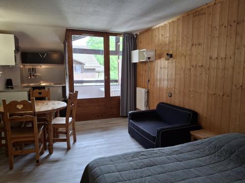 une chambre avec un lit et une table et une cuisine dans l'établissement Studio avec Balcon Exposé Est, Parking et WIFI Inclus - Brides-les-Bains - FR-1-512-186, à Brides-les-Bains