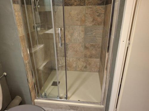 une douche avec une porte vitrée dans une salle de bain dans l'établissement Studio avec Balcon Exposé Est, Parking et WIFI Inclus - Brides-les-Bains - FR-1-512-186, à Brides-les-Bains