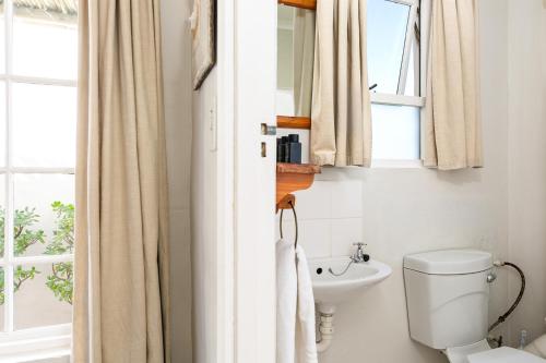 a bathroom with a toilet and a sink at Adventure Pad's by The Farmhouse Hotel in Langebaan