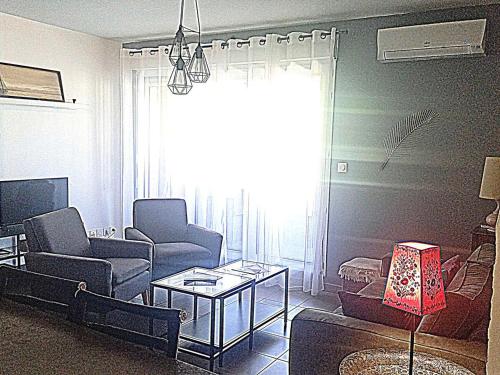 un salon avec un canapé, des chaises et une table dans l'établissement Séjour à Sète : Bel Appartement 3 Pièces avec Loggia, Proche Plage et Commerces - FR-1-472-153, à Sète