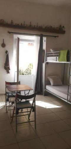 Cette chambre comprend une table et une chaise. dans l'établissement l'Entre Girls, à Cassis