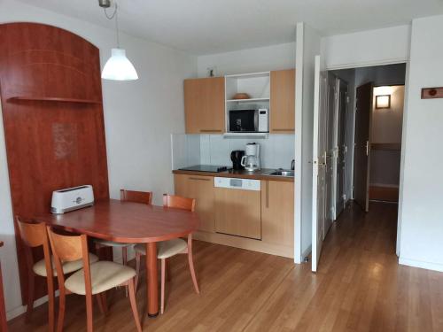 une cuisine et une salle à manger avec une table et des chaises dans l'établissement Charmant studio cabine pour 4 avec terrasse, piscine couverte, parking et salle de fitness à 400m des pistes - FR-1-404-245, à Bagnères-de-Bigorre