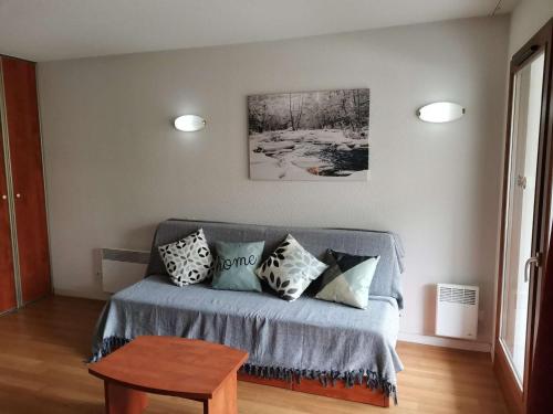 - un salon avec un canapé et des oreillers dans l'établissement Charmant studio cabine pour 4 avec terrasse, piscine couverte, parking et salle de fitness à 400m des pistes - FR-1-404-245, à Bagnères-de-Bigorre