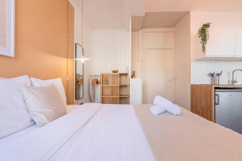 Cette chambre comprend un grand lit blanc et une cuisine. dans l'établissement Charming Lille St Michel studio, à Lille