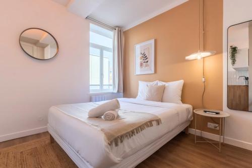 une chambre avec un grand lit blanc avec un miroir dans l'établissement Charming Lille St Michel studio, à Lille