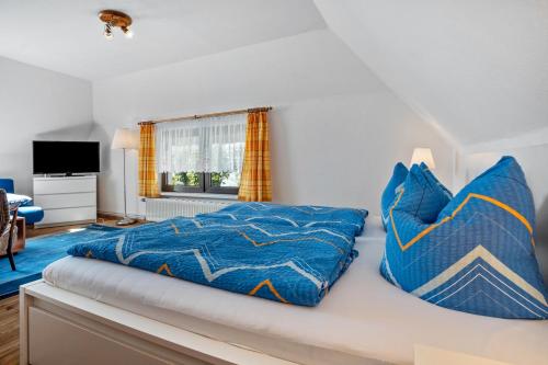 a bedroom with a couch with blue pillows at Ferienwohnung 4 in Groß Zicker
