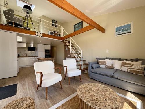 un salon avec un canapé et un escalier dans l'établissement Maison bord de mer à St-Denis-d'Oléron, 6 pers, 3 ch, terrasse, vélos, plage à 2 pas - FR-1-246A-230, à Saint-Denis-dʼOléron