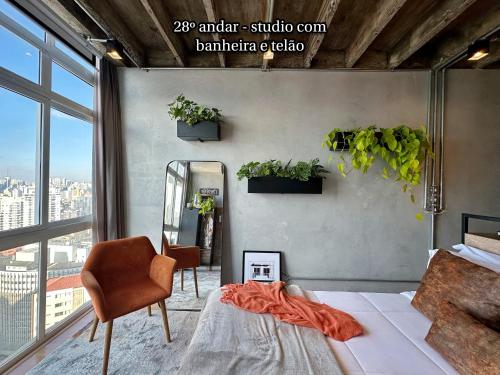 a bedroom with a bed and a chair and a mirror at Vem pro Copan in Sao Paulo