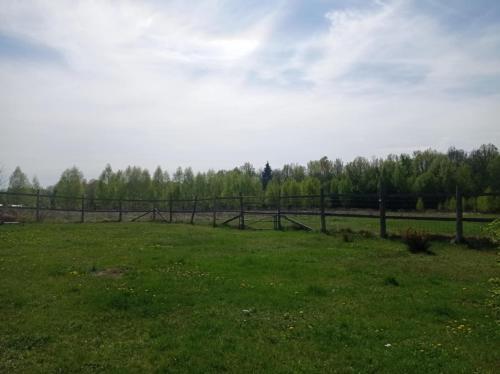 a grassy field with a fence in the distance at Domek kempingowy Przy Siole Budy in Budy