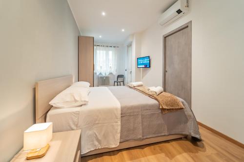 a bedroom with a large bed and a television at Dimora Bassignano in Cuneo