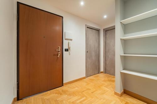a hallway with a wooden door and shelves at Dimora Bassignano in Cuneo