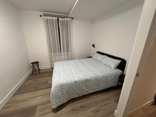 a white bedroom with a bed and a window at La Ventana de San Isidoro in León