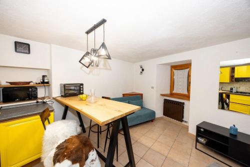 a kitchen with a table and a dog in a room at Maison Citron - Explore Courmayeur Mont Blanc in Villair