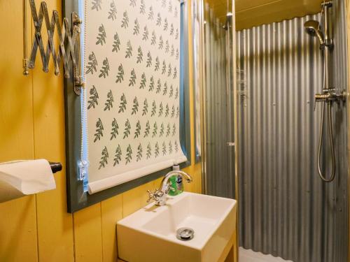 a bathroom with a sink and a shower at Oak Shepherd Hut in Bridport