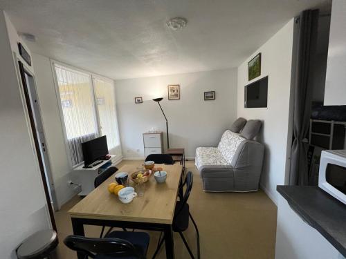 un salon avec une table et un canapé dans l'établissement Appartement SENILLADES à Saint Pierre La Mer, à Saint Pierre La Mer