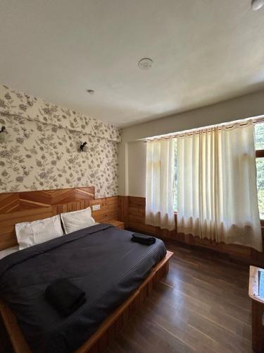 a bedroom with a bed and a window at Byway, Kasol in Manīkaran