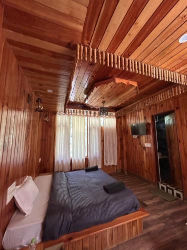 a bedroom with a bed in a wooden room at Byway, Kasol in Manīkaran