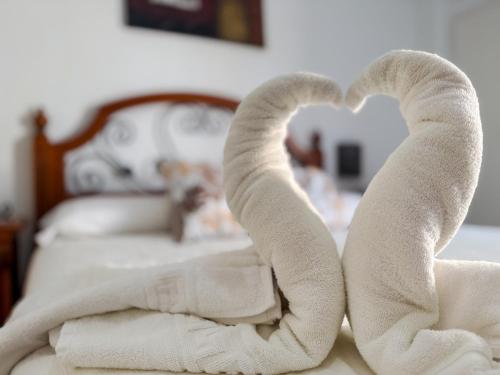 a bed with towels in the shape of a heart at El Delfín in Playa de las Americas
