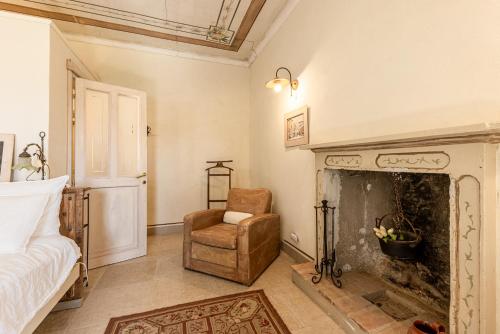 a living room with a fireplace and a chair at Le libellule relais in San Lorenzo