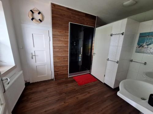 a bathroom with a shower and a red rug at Nordseehostel am Bahnhof in Sande