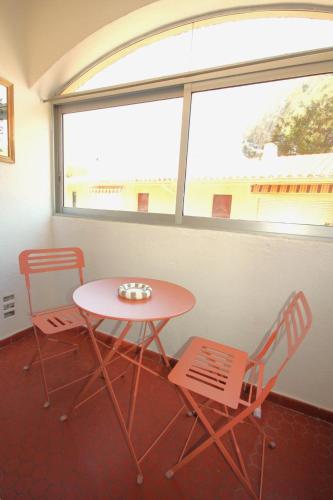 une table et des chaises dans une pièce avec une fenêtre dans l'établissement Le Cosy, à Collioure