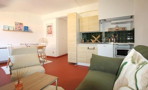 un salon avec un canapé et une cuisine dans l'établissement Le Cosy, à Collioure