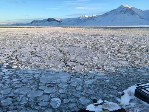 a cracked ice field with a mountain in the background at Art & Nature Retreat in Iceland - The Crib Rocks in Borgarnes