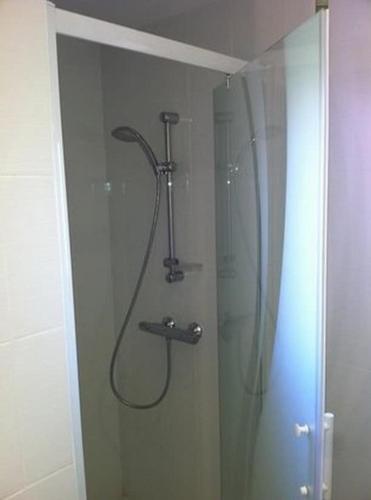 une douche dans une salle de bain avec une porte vitrée dans l'établissement House Golfe Juan, à Vallauris