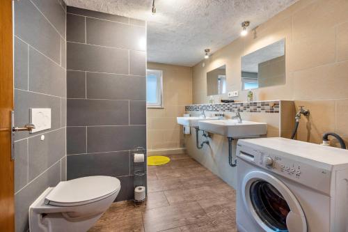 a bathroom with a toilet and a sink and a washing machine at Bad day good day in Horn-Bad Meinberg