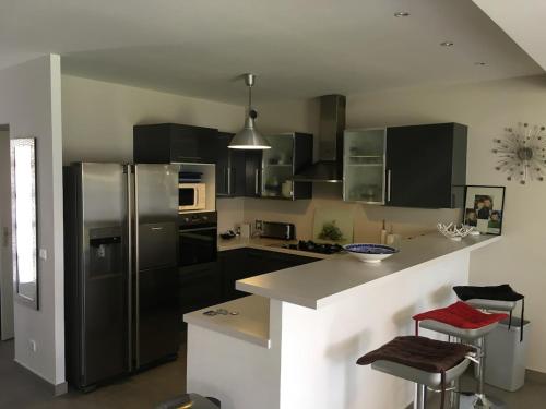 une cuisine avec des appareils électroménagers en acier inoxydable et des armoires noires dans l'établissement House Golfe Juan, à Vallauris