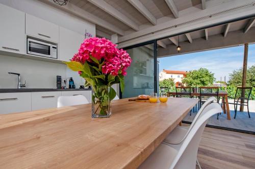 a vase filled with pink flowers sitting on a wooden table at VILLA MARE, ISTRA, relaxation, private pool, BBQ in Šegotići
