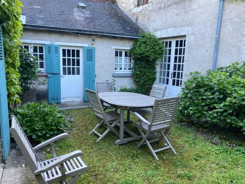 une table et des chaises devant une maison dans l'établissement Gîte face à la Loire, à Saint-Dyé-sur-Loire