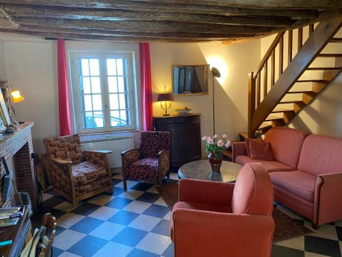 - un salon avec un canapé, des chaises et un escalier dans l'établissement Gîte face à la Loire, à Saint-Dyé-sur-Loire