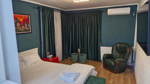 a bedroom with a bed and a chair and a window at Casa Damian DROBETA in Drobeta-Turnu Severin