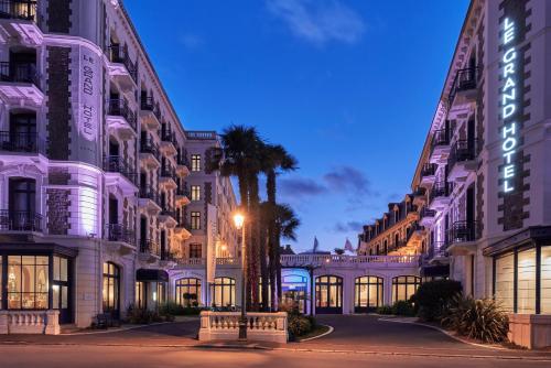a street in front of buildings at night at Hôtel Barrière Le Grand Hôtel Dinard in Dinard