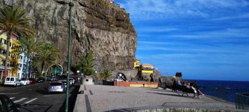 a street in front of a mountain with the ocean at SUNSCAPE Ocean Apt de 1 quarto Ponta do Sol in Ponta do Sol