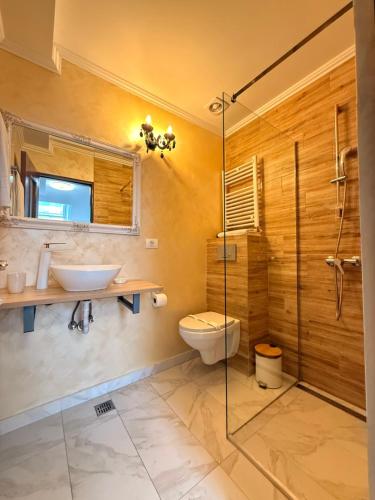 a bathroom with a toilet and a sink and a shower at Vila Central in Constanţa