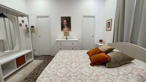 a bedroom with a bed with an orange pillow on it at Villa Nanni - Camera Puccini ao lado da Mura in Lucca
