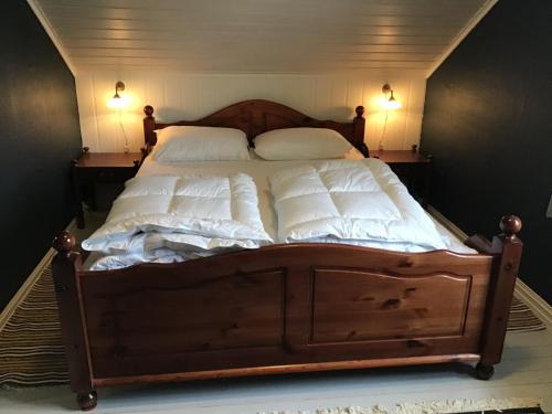 a large bed with white sheets and pillows on it at Gamlemgarden by Norgesbooking - house by the sea in Longva