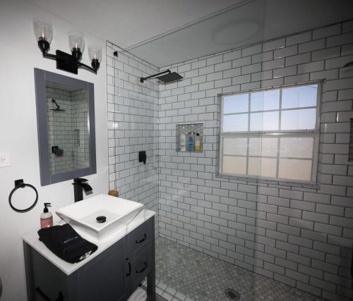 a white bathroom with a sink and a window at Granbury Loft - 1 Bedroom in Granbury
