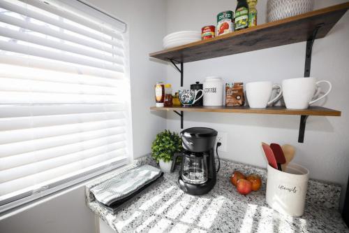 a kitchen counter with a coffee maker on a shelf at Granbury Loft - 1 Bedroom in Granbury