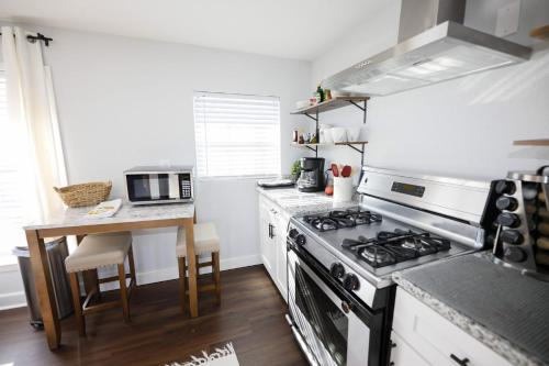 a kitchen with a stove and a small table at Granbury Loft - 1 Bedroom in Granbury