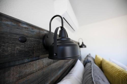 a black lamp hanging on a wall above a couch at Granbury Loft - 1 Bedroom in Granbury
