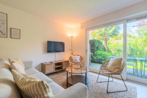 un salon avec un canapé et une télévision dans l'établissement Maison 4 chambres avec jardin & garage proche tram, à Wasquehal